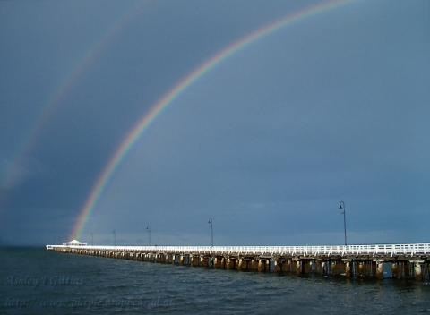From November 2004. A thunderstorm had just passed out to the east, the sun was setting beneath the remaining cloud. I figured there was a good chance for a rainbow over the Sandgate jetty, the drive was worth it.